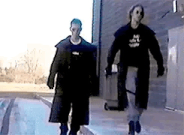Eric Harris and Dylan Klebold in trench coats at Columbine High School in the video Hitmen for Hire