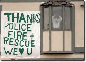 Neighbors of Columbine High hang a thank you banner for police, fire, and rescue workers