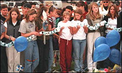 Middle-schoolers hold a chain with memorial statements on it