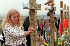 Mourners visit the memorial crosses