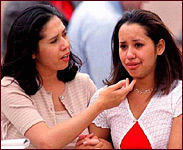 A mother comforts her daughter after their reunion