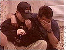 Having found each other, father and son share a tearful moment